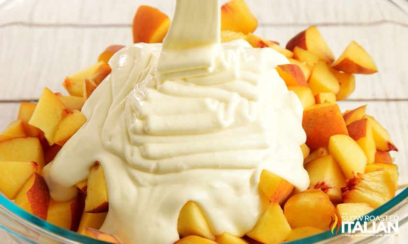 adding cheesecake mixture to peaches