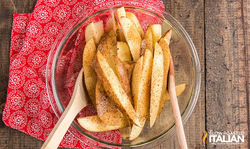 tossing fresh cut potato wedges with Red Robin fry seasoning