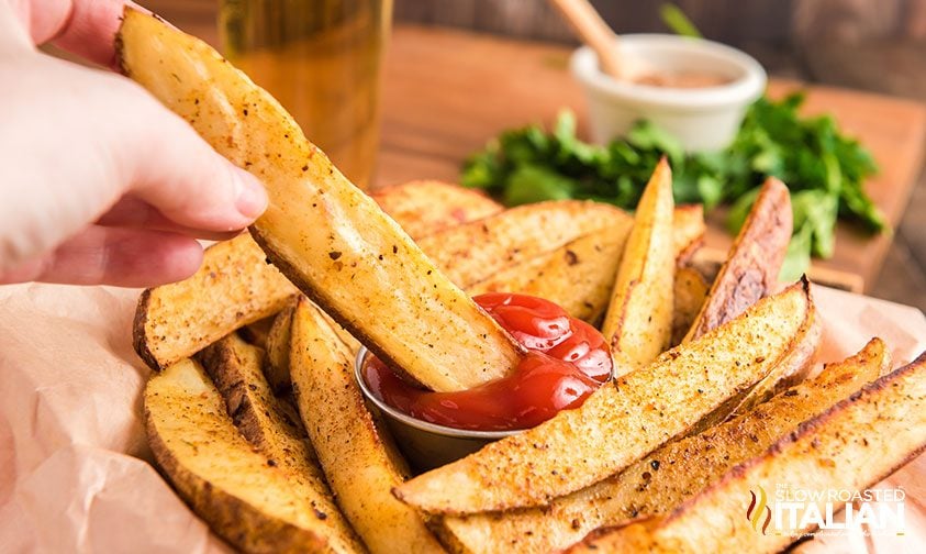 dipping seasoned Red Robin fries in ketchup