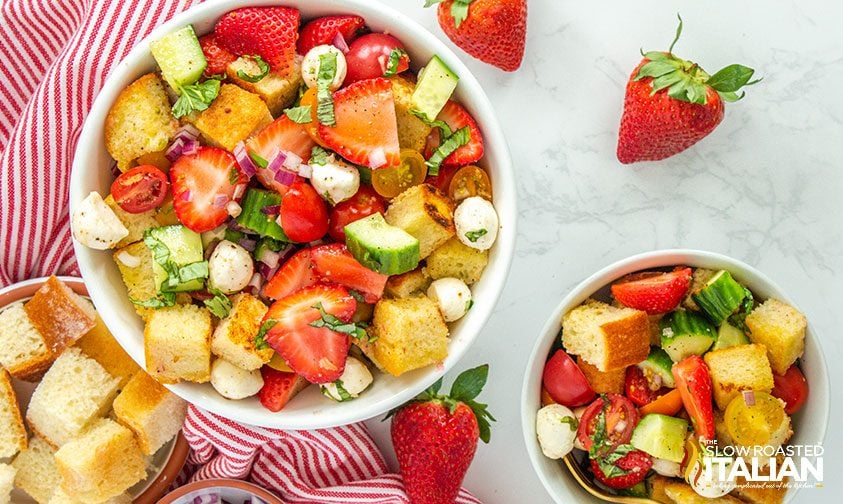 large bowl of strawberry panzanella with smaller bowls of salad and bread cubes