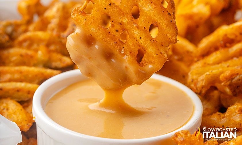 closeup of waffle fry dipped in creamy sauce