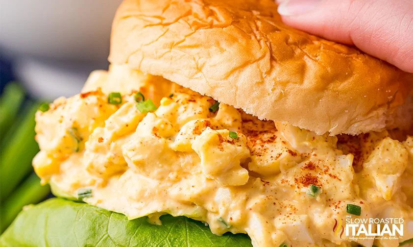 close up of egg salad and lettuce on hamburger bun