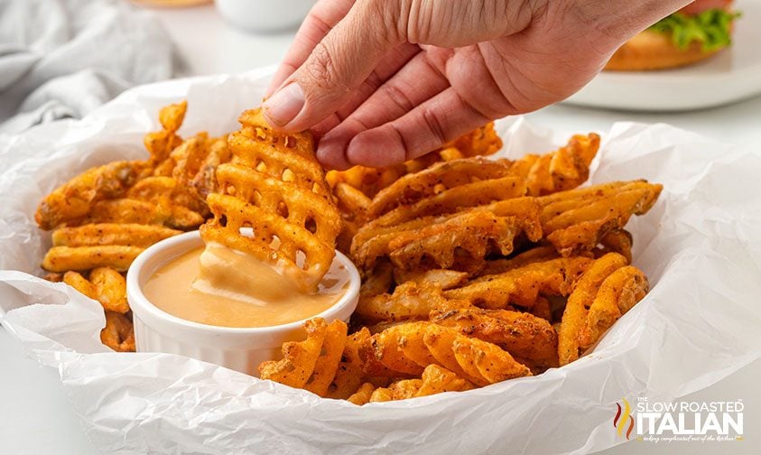 dipping waffle fries in creamy sauce