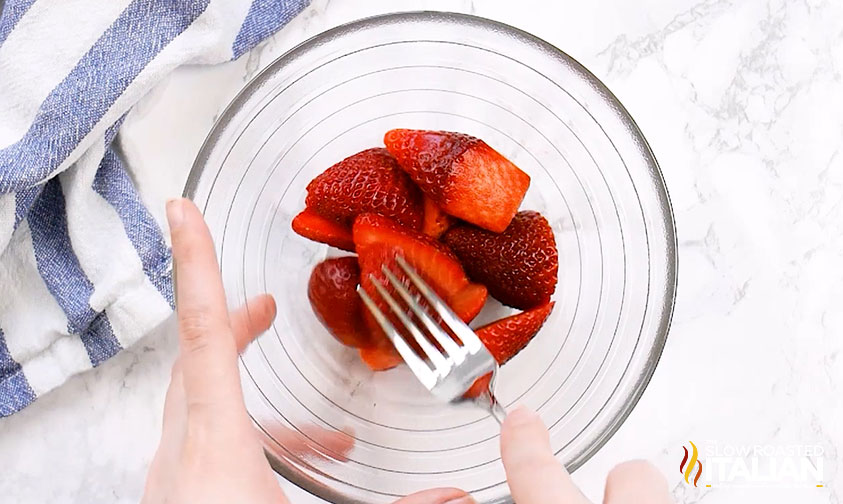 mashing strawberries with a fork