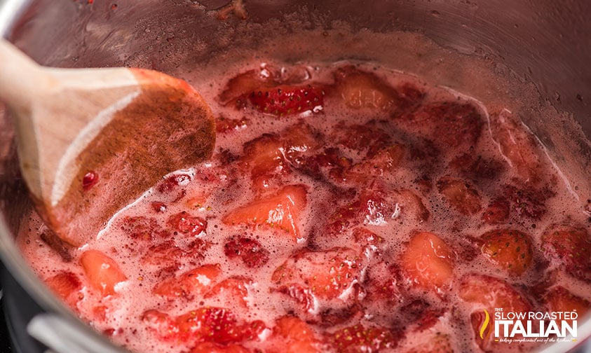 stirring and simmering strawberry syrup