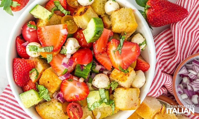 close up of panzanella salad with strawberries in large bowl