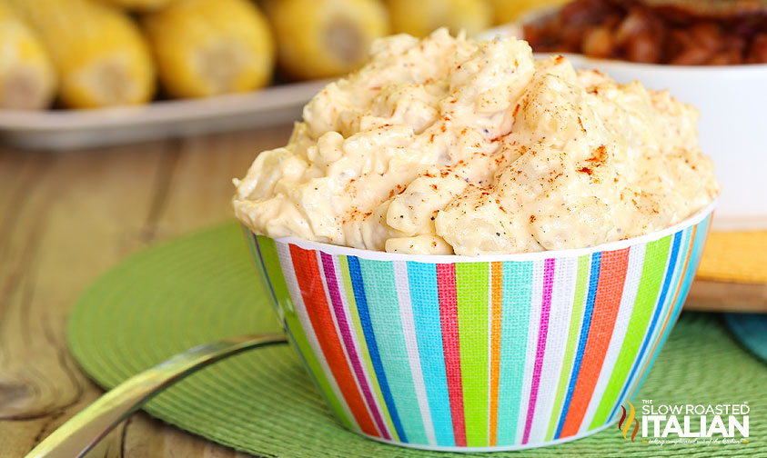 colorful striped bowl of potato salad