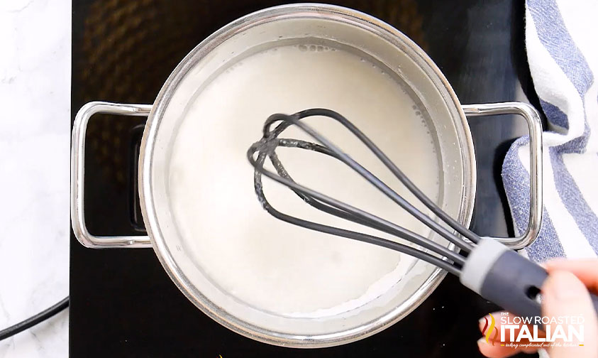 whisking strawberry filling base in a pot