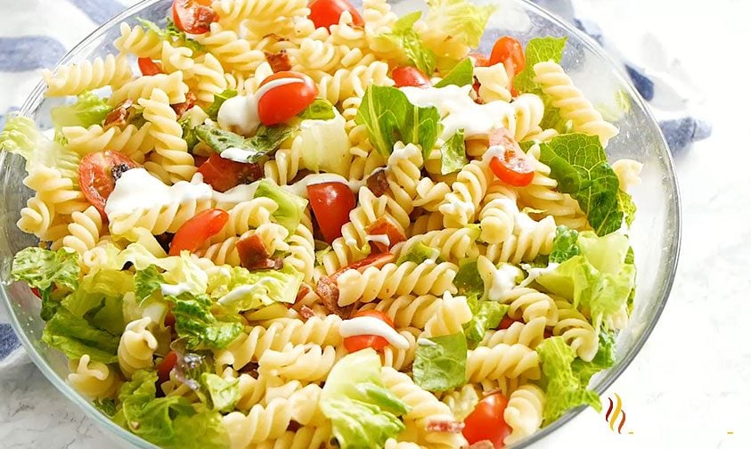 overhead: bowl of pasta salad with lettuce, bacon, and tomatoes