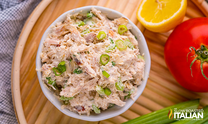 overhead: bowl of chicken salad with celery and herbs