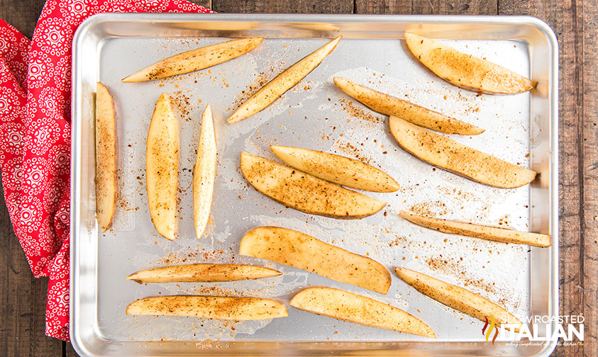 seasoned potato wedges on a baking sheet