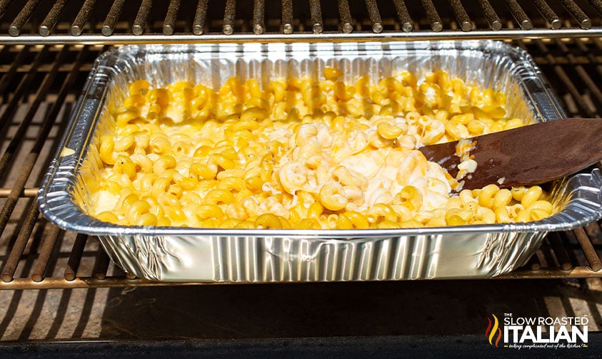 stirring mac and cheese in foil pan on smoker