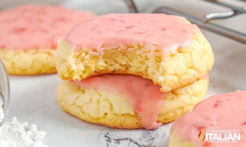 bitten cookie with strawberry glaze stacked on top of another cookie