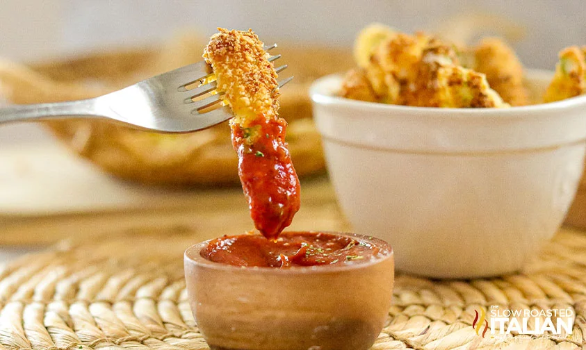 fork dipping zucchini fry in spicy ketchup