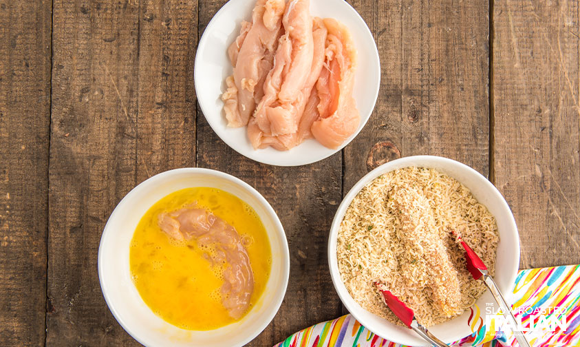 dredging chicken tenderloins in egg mixture and breadcrumbs