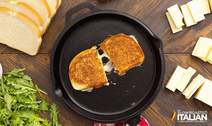 halved grilled cheese pulled apart in skillet