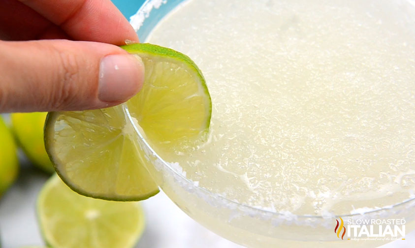 placing lime slice on rim of margarita with salt