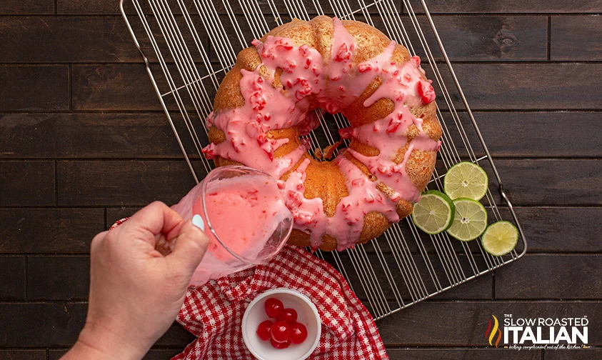 pouring cherry glaze over bundt cake