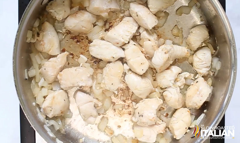 browned chicken and onions in a skillet