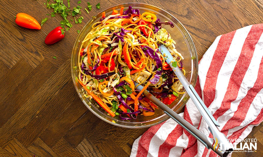 asian noodle salad tossed with tongs