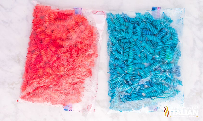 two bags of dyed rotini, one red and one blue