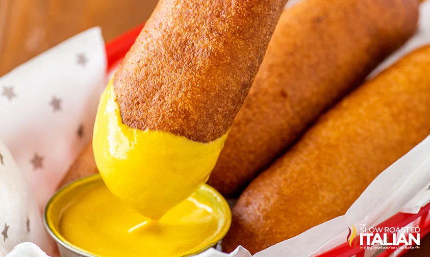 dipping corn dog in mustard