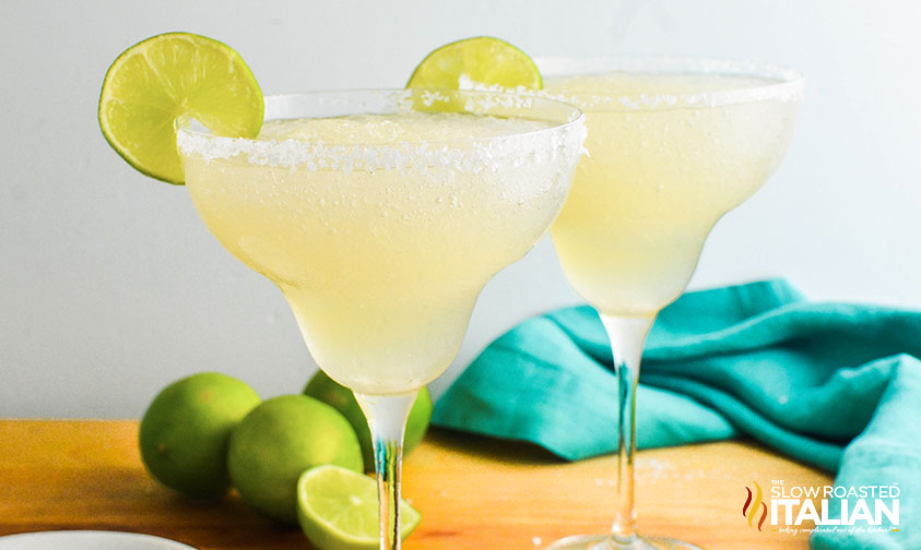 two frozen margaritas garnished with lime
