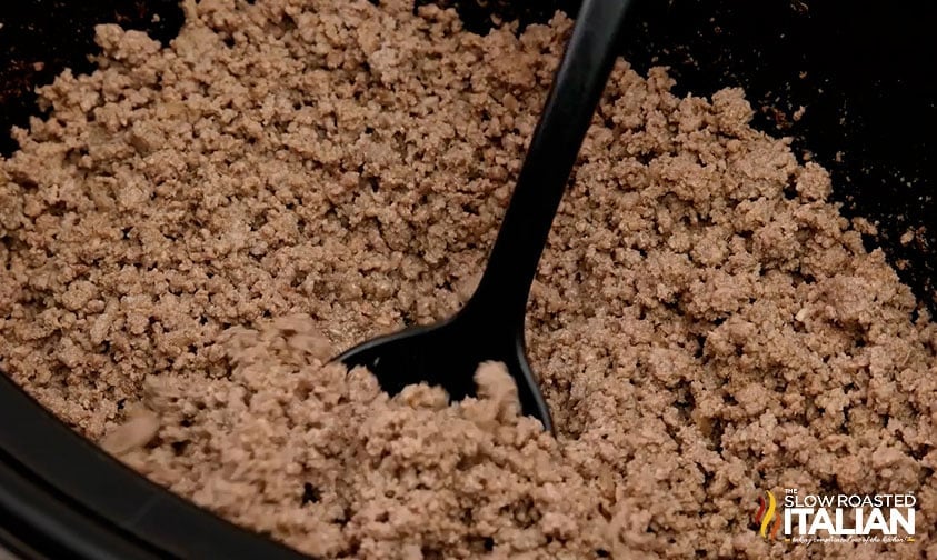 scooping cooked ground beef out of slow cooker