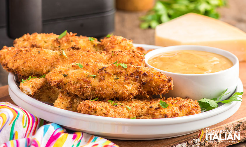 breaded chicken tenders on plate with sauce