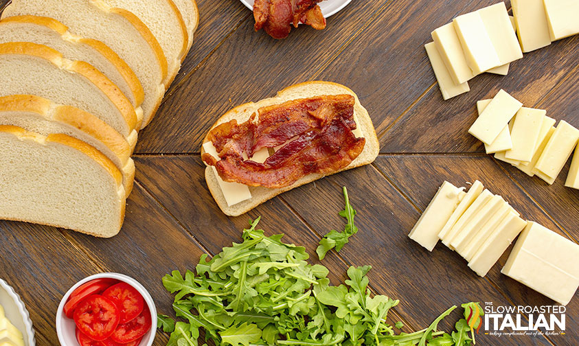 cheese and bacon layered on slice of bread