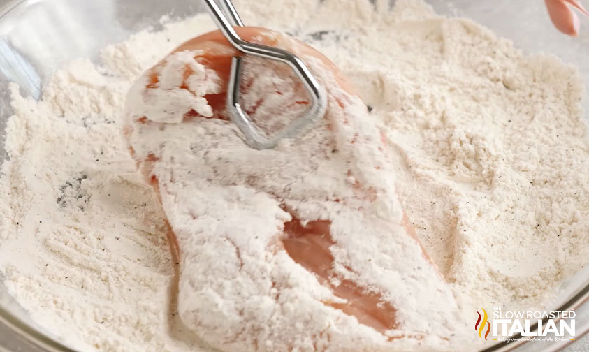 dredging chicken in flour with tongs