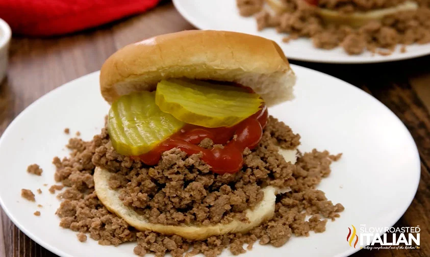 loose meat sandwich with pickles and ketchup