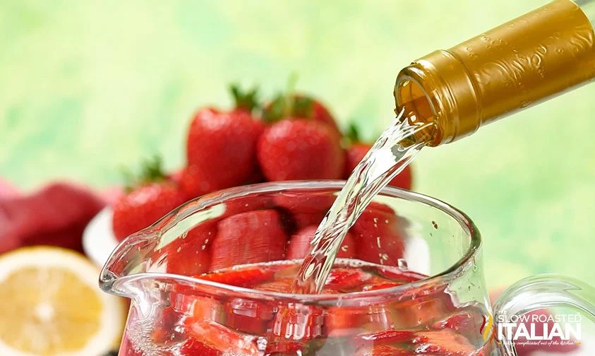 pouring moscato wine into pitcher with berries