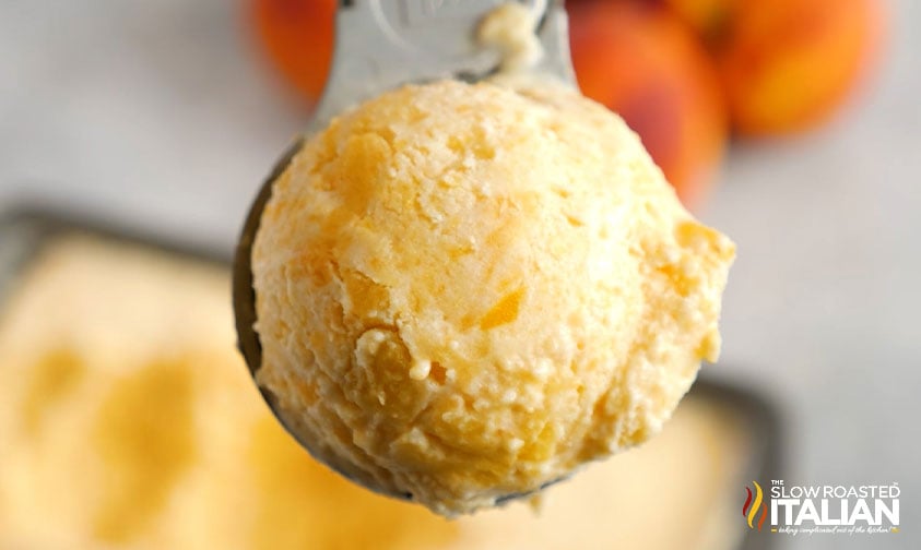 close up: scoop of peach ice cream with fruit chunks