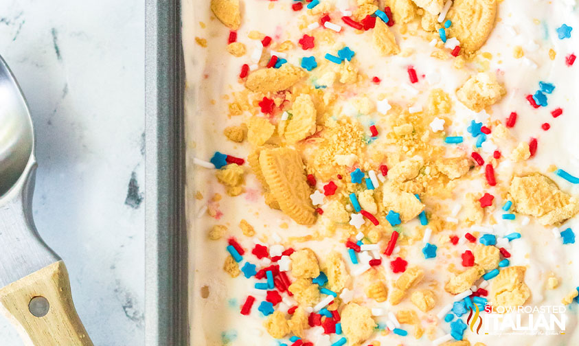 vanilla ice cream base with sprinkles and cookies in container