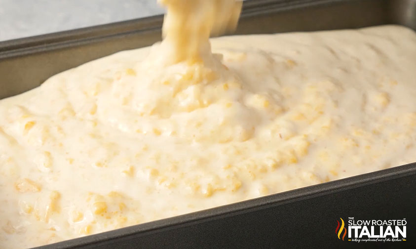 pouring peach ice cream base into metal loaf pan