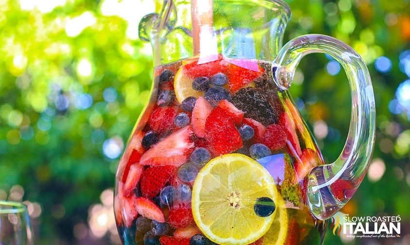 pitcher of sangria with fresh berries and lemon slices