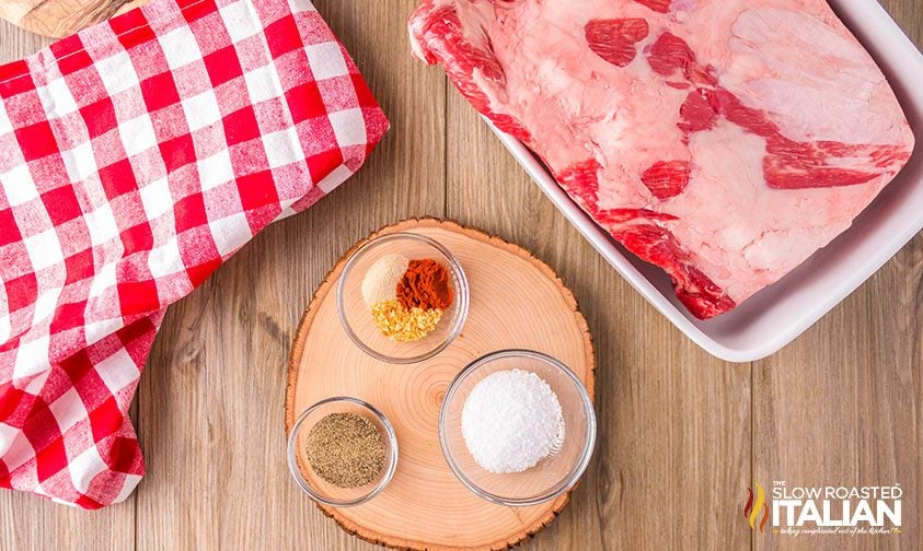 bowls of spices next to slab of beef ribs