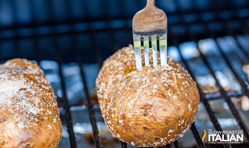 fork inserted into potato on smoker