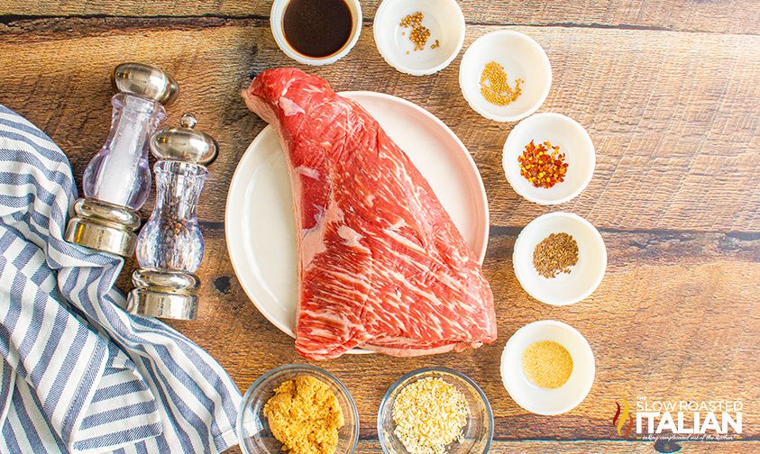 uncooked tri tip surrounded by dry rub ingredients