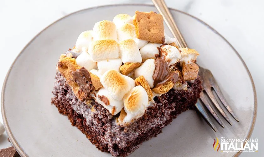 slice of smores cake on a plate with fork