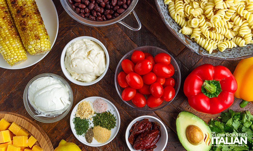 table full of ingredients for southwest pasta salad