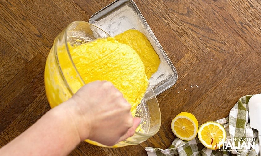 pouring lemon loaf batter into greased and floured loaf pan