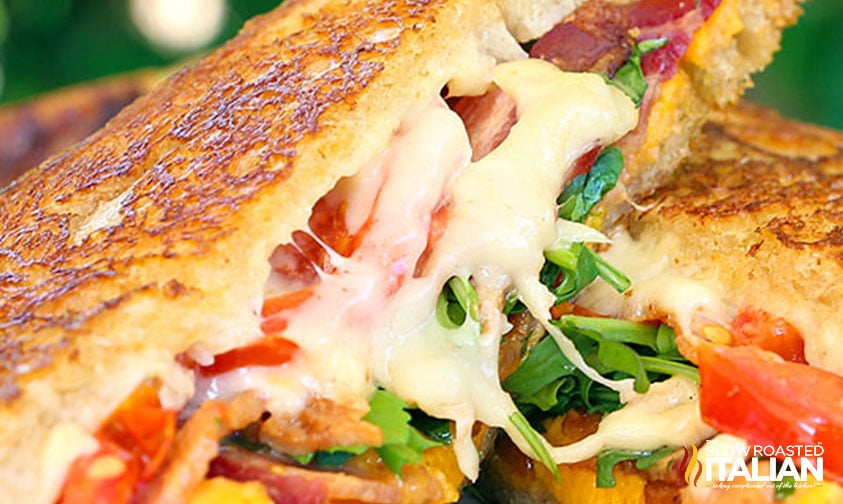 showing inside grilled cheese with bacon, tomato, and arugula