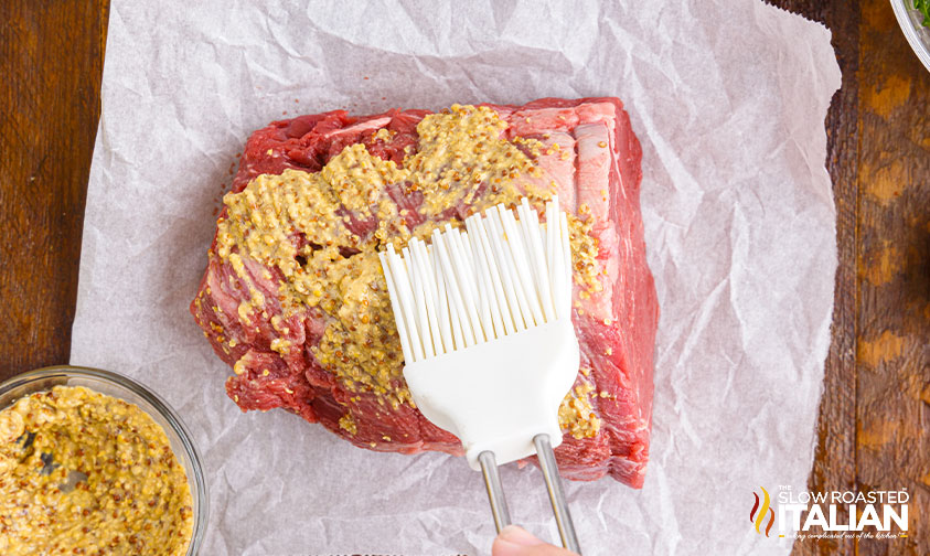 slathering tenderloin with ground mustard