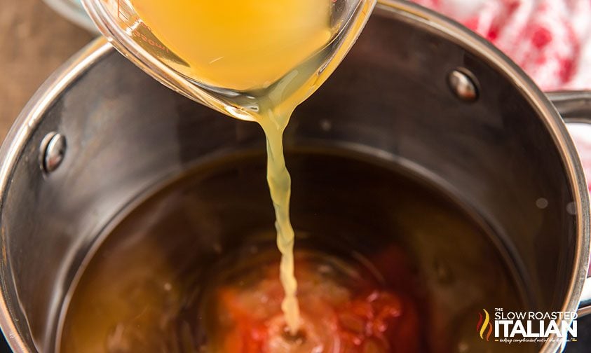pouring pineapple juice into saucepan with sweet and sour ingredients