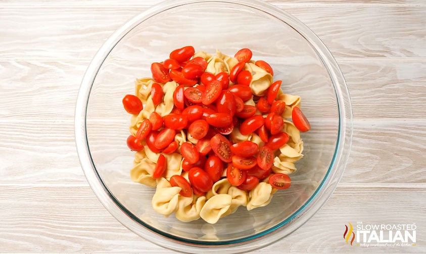 cooked tortellini in a bowl with sliced tomatoes