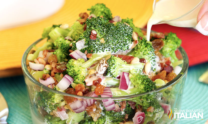 pouring creamy dressing over broccoli bacon salad