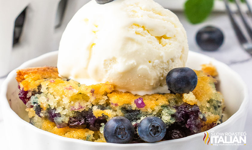 blueberry cobbler in a bowl with a scoop of ice cream