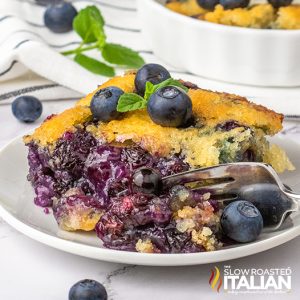 blueberry cobbler on a white plate with a fork